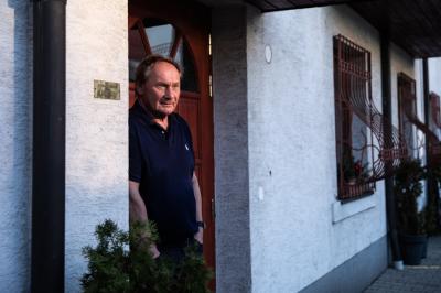 Jiří Novák stojí u dveří u budovy
