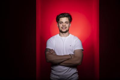 Matěj Blümel před červeným pozadím