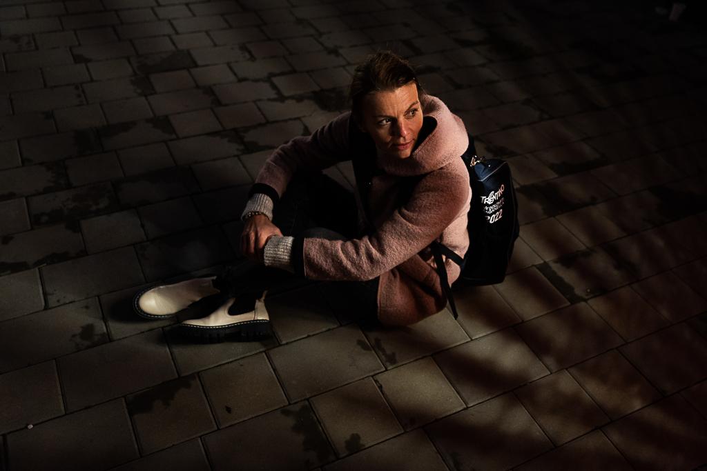 Jindřiška Zemanová sedí s batohem na zádech ve stínu.