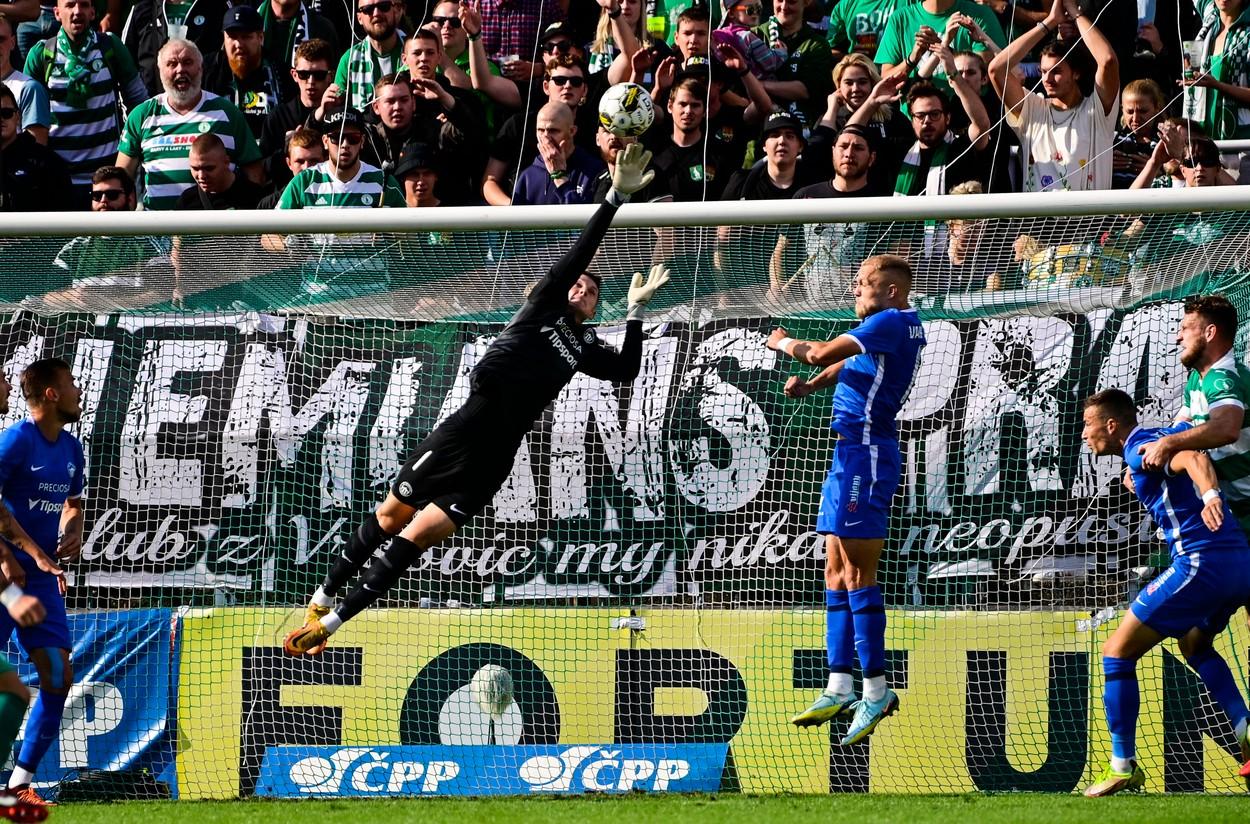 Olivier Vliegen při výskoku chytá míč při fotbalovém zápase