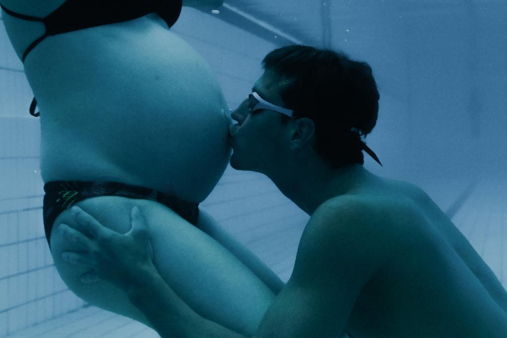 Jan Micka pod vodou líbá těhotenské bříško své manželky