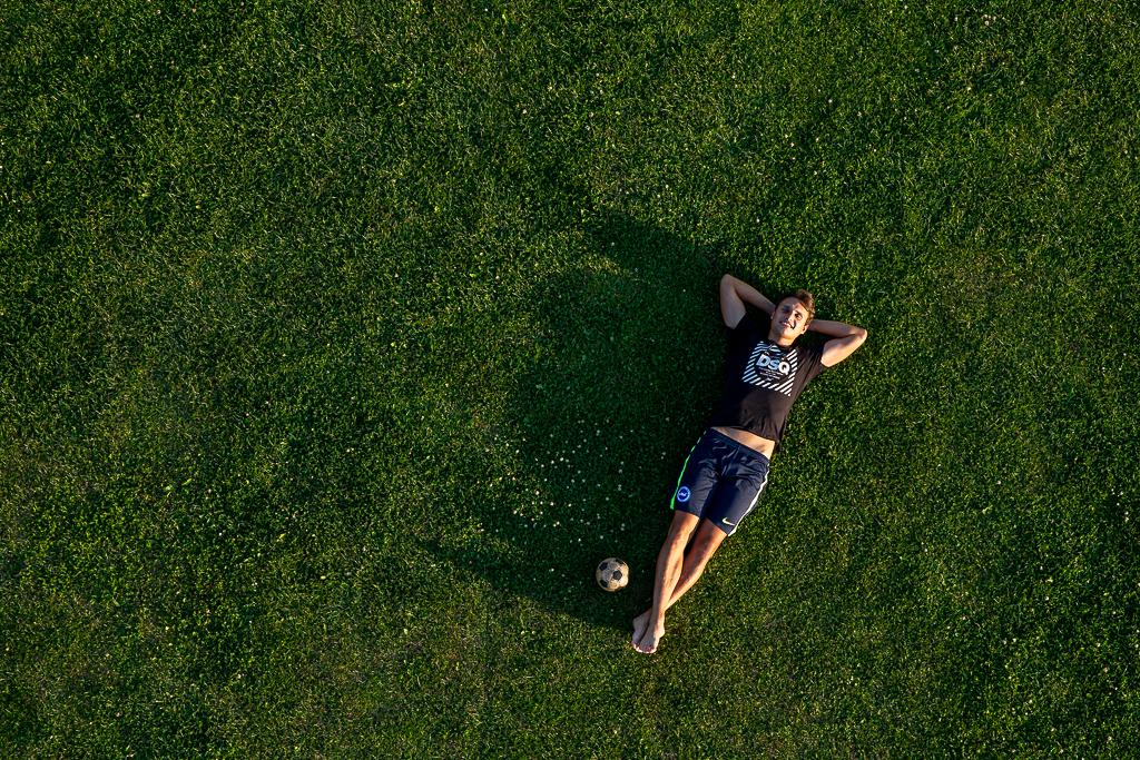 Aleš Matějů leží v trávě na zádech na fotbalovém hřišti