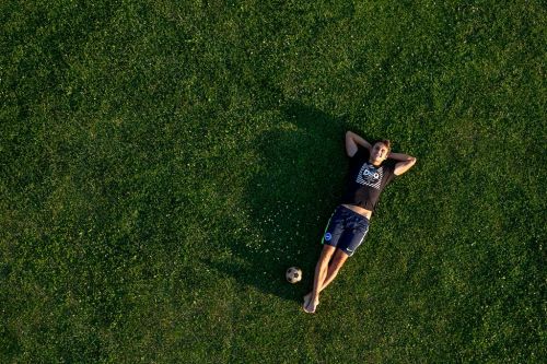Aleš Matějů leží v trávě na zádech na fotbalovém hřišti