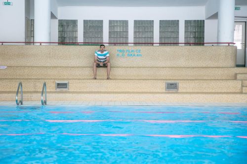 Daniel Málek sedí na tribuně u bazénu