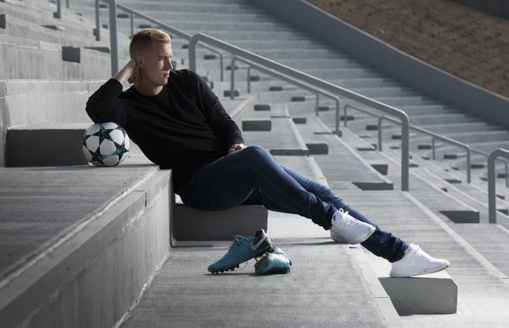 Jan Baránek sedí na schodech fotbalového stadionu s míčem