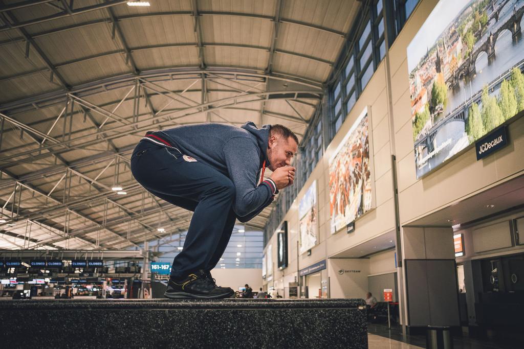 Jan Hudec imituje svojí startovní pozici v odletové hale na letišti