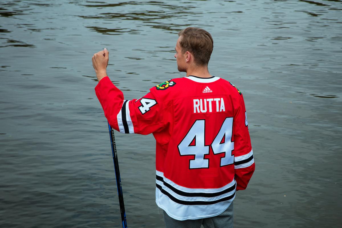 Jan Rutta stojí v hokejovém dresu před Vltavou