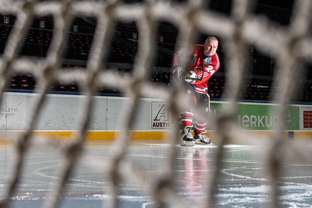 Jiří Hrdina odehrává puk do brány na ledě v aréně HC Sparta Praha, má na sobě hokejovou výstroj