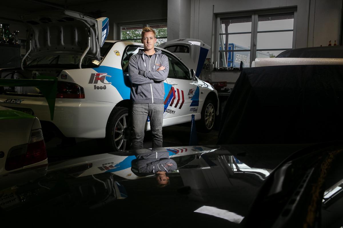 Martin Semerád se v garáži opírá o sportovní auto.