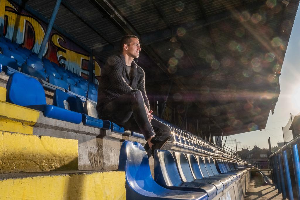 Matej Rakovan sedí na žlutomodrých lavičkách.