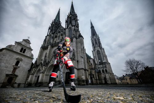 Matouš Maxmilián Venkrbec stojí v hokejovém před kostelem.