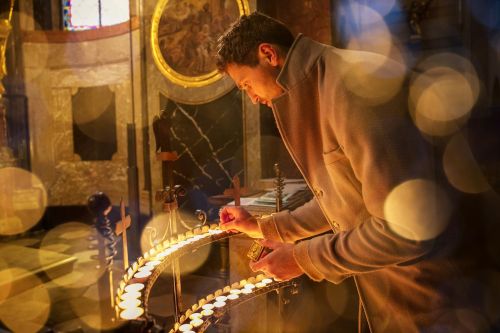 Matouš Maxmilián Venkrbec zapaluje svíčku v kostele.