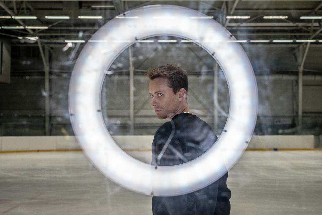 Michal Březina se dívá skrz osvětlený kruh na plexiskle.