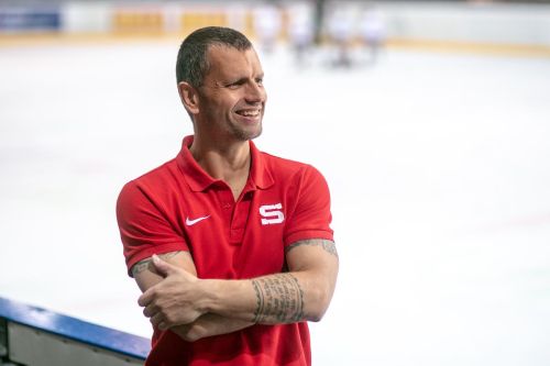 Michal Broš stojí na střídačce holešovické hokejové haly.