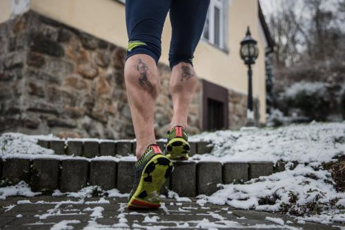 Nohy Miloše Škorpila s tetováními za běhu.