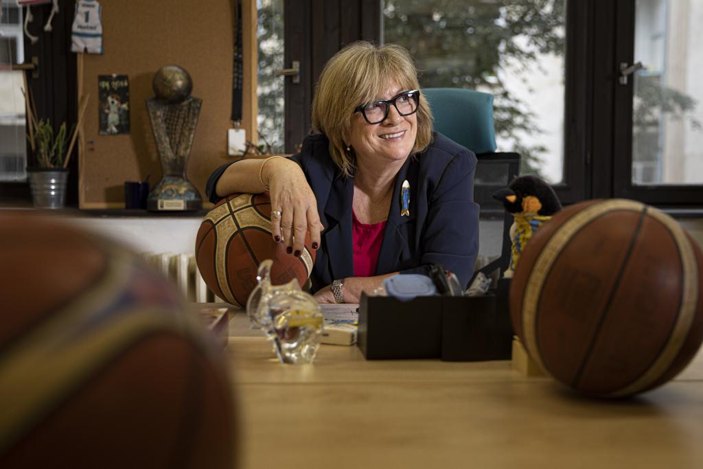Natália Hejková v kanceláři s basketbalovými míči a trofejí