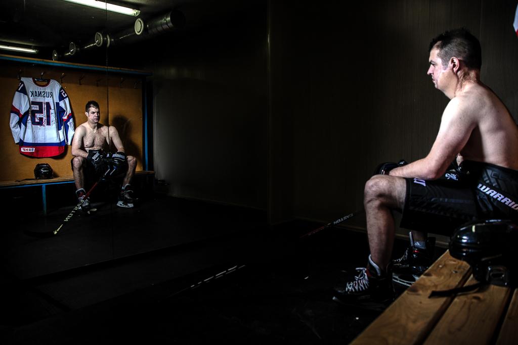 Ondrej Rusnák se na sebe dívá do zrcadla v hokejové kabině.