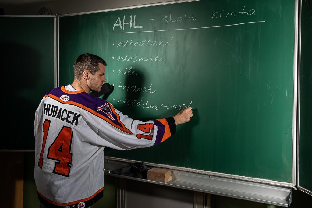 Petr Hubáček v dresu píše na školní tabuli.