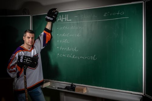 Petr Hubáček se v hokejovém opírá o popsanou školní tabuli.