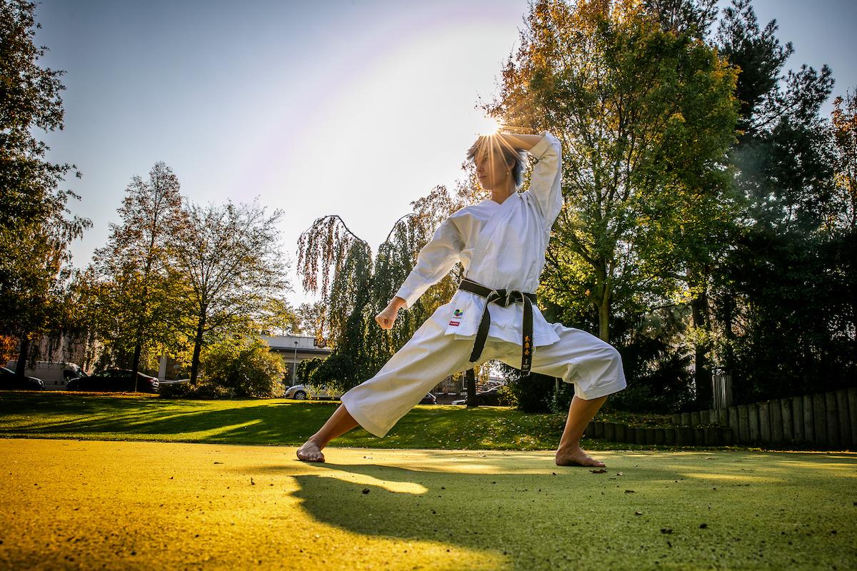 Petra Nová trénuje karate v podzimním parku.