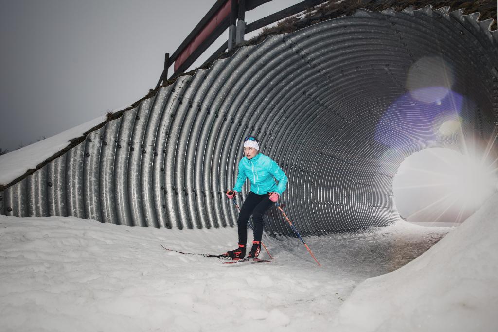 Petra Nováková vyjíždí na lyžích z tunelu.