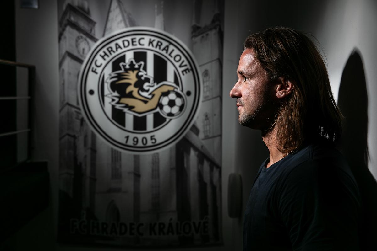 Radim Ottmar na pozadí s logem fotbalového klubu Hradec Králové.