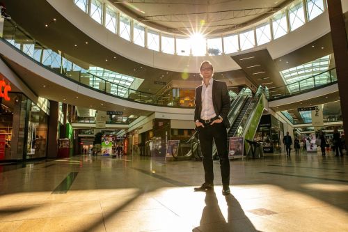 Robert Sovík stojí v nákupním centru Harfa před eskalátory, svítí na něj slunce
