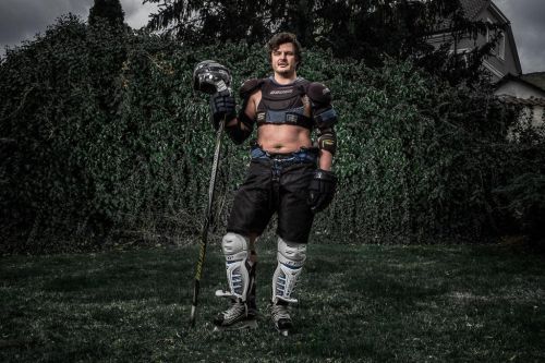 Roman Staša stojí venku v hokejové výstroji.
