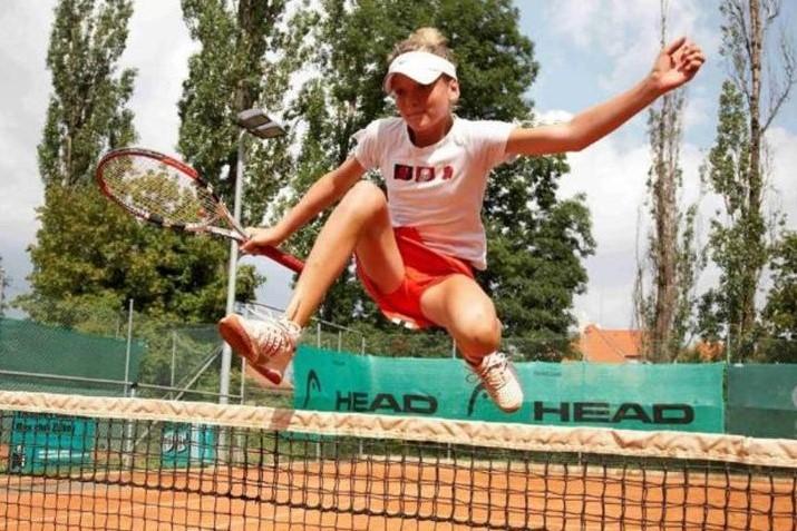 Tereza Martincová přeskakuje tenisovou síť.