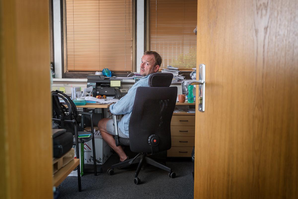 Tomáš Dvořák se ve své kanceláři ohlíží ke dveřím.