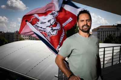 Tomáš Rolinek stojí u zábradí na Enteria aréně v Pardubicích, za ním vlaje vlajka HC Pardubice