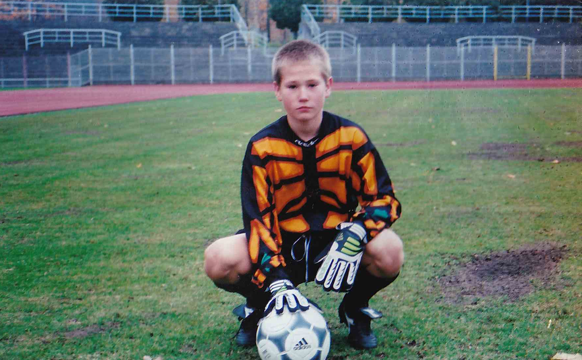 mladý Tomáš Vaclík v brankářském dresu s rukavicemi a míčem na fotbalovém stadionu