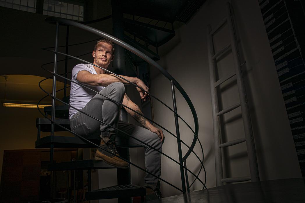 Václav Nedorost sedí na točitém schodišti.