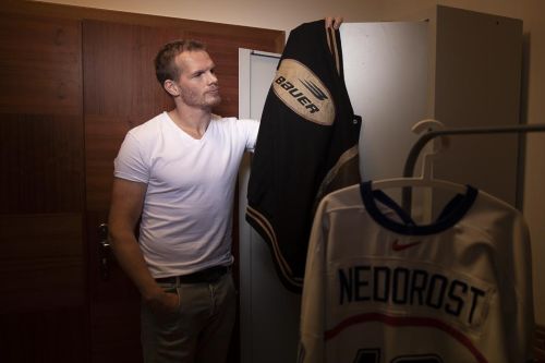 Václav Nedorost si prohlíží své hokejové dresy.