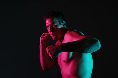 Viktor Pešta v barevných světlech a typickém gestu zápasníka MMA.