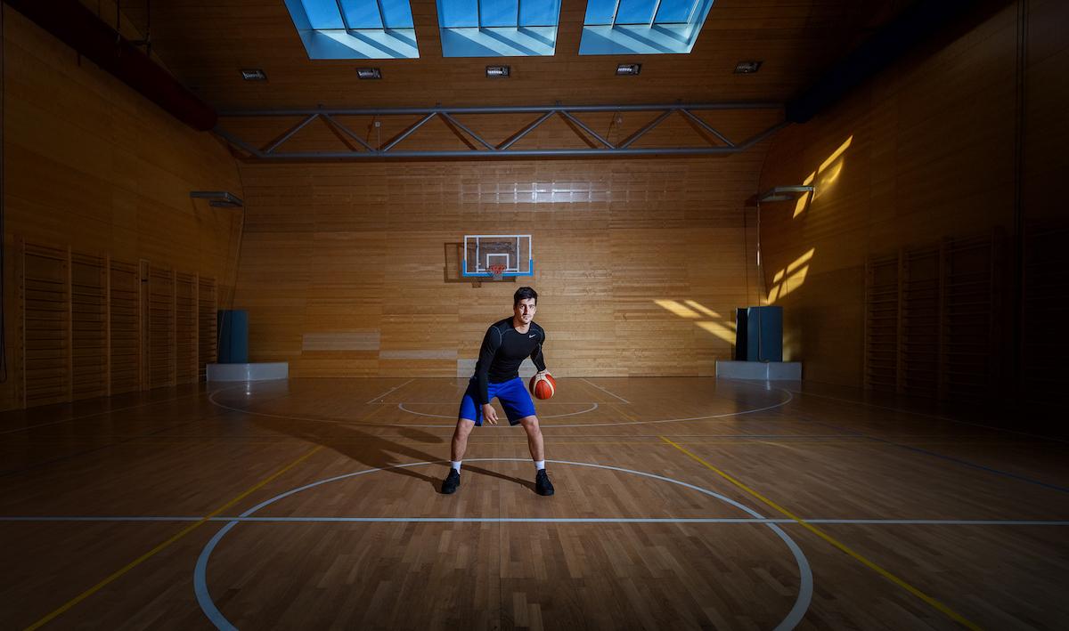 Zurab Kereselidze stojí v tělocvičně s basketbalovým míčem