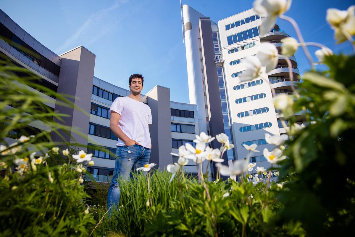 Zurab Kereselidze stojí před budovou v trávě mezi květinami